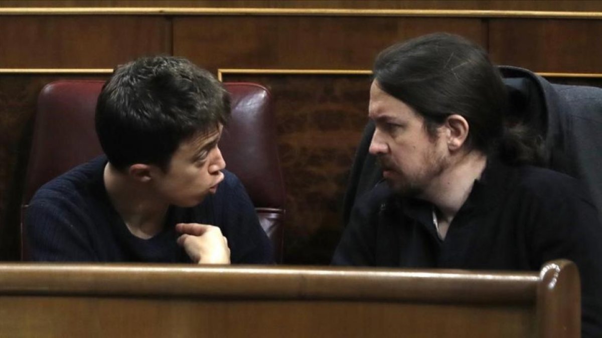 Los máximos dirigentes de Podemos, Iñigo Errejón y Pablo Iglesias, discuten en sus escaños del Congreso.-EFE