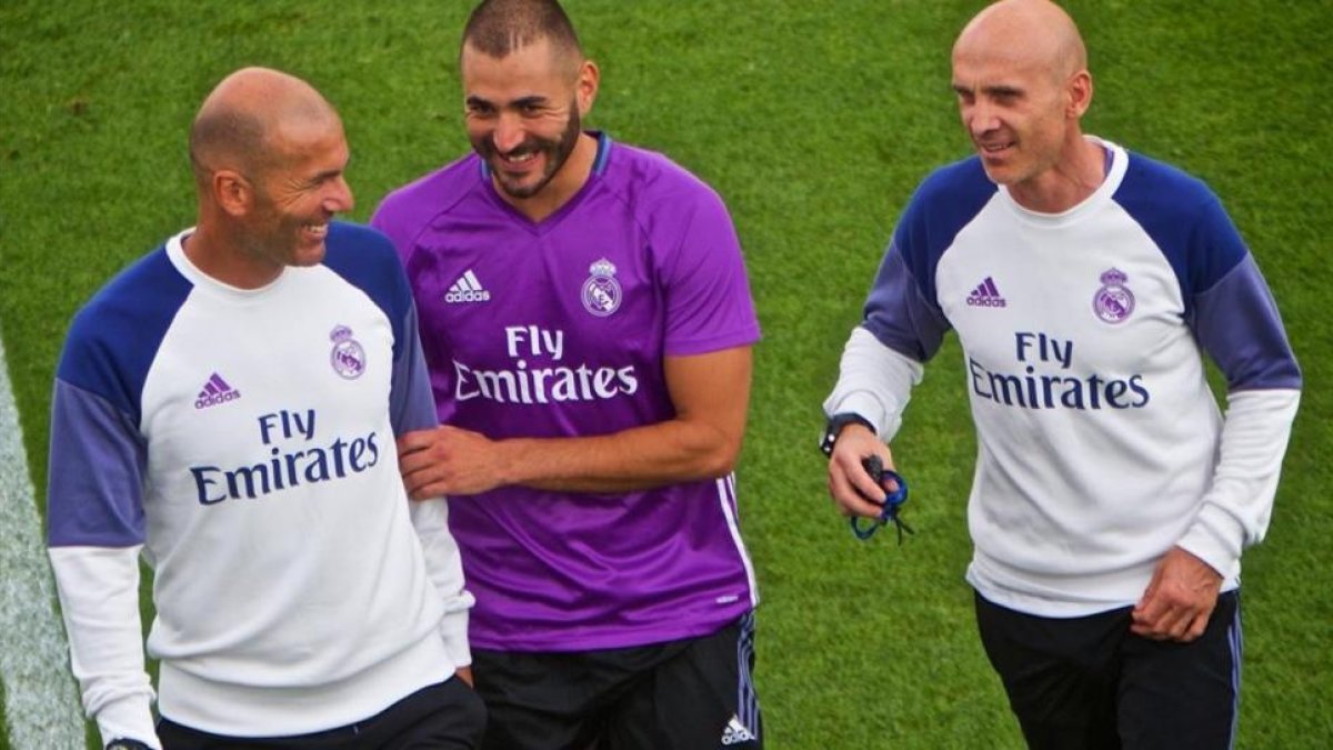 Zidane bromea junto a Zidane y a David Bettoni, uno de sus ayudantes, en el último entrenamiento del Madrid en Montreal.-EFE / ANDRE PICHETTE