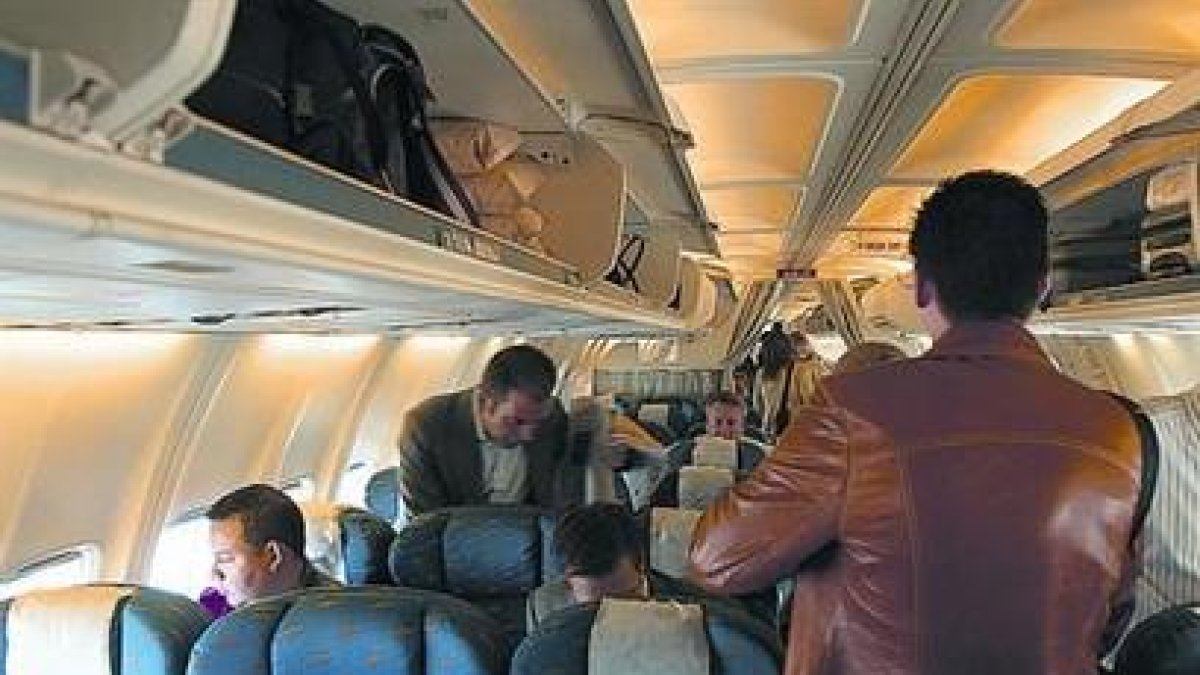 Varios pasajeros se acomodan en un avión del puente aéreo.-ARCHIVO / JON BARANDICA