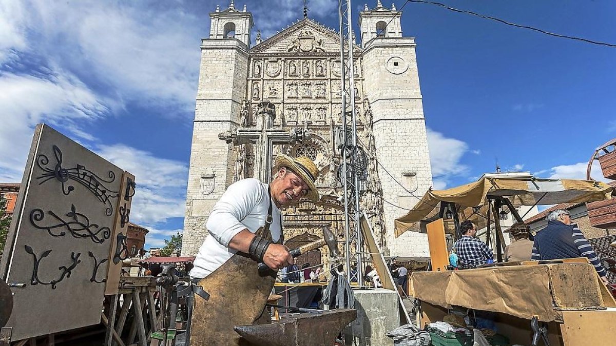 Un herrero enseña su oficio con la iglesia de San Pablo de fondo.-PABLO REQUEJO