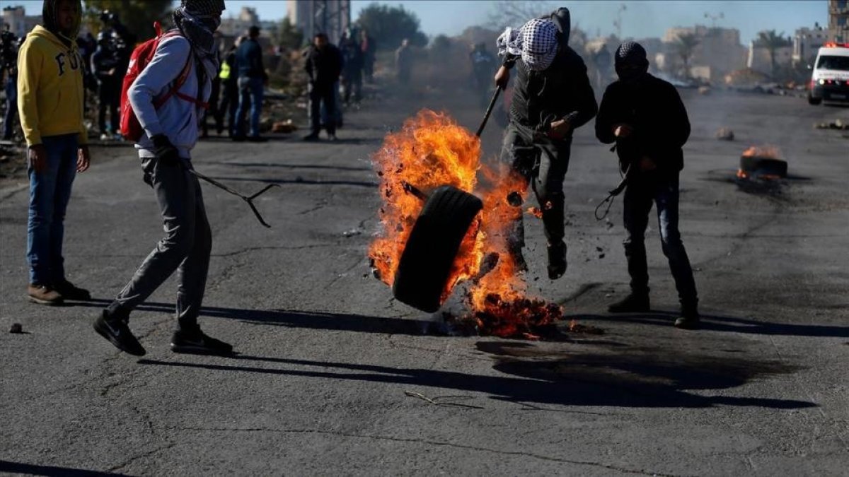 Manifestantes palestinos queman un neumático en protesta por la decisión de EEUU, en Ramalá, este martes 26 de diciembre-AFP / ABBAS MOMANI