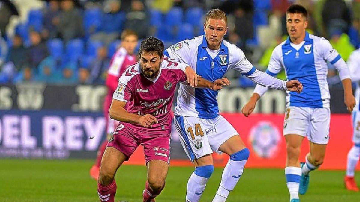 Villalibre corre tras el balón ante la mirada de Raúl García y Bustinza en el partido disputado ayer en Butarque.-LOF