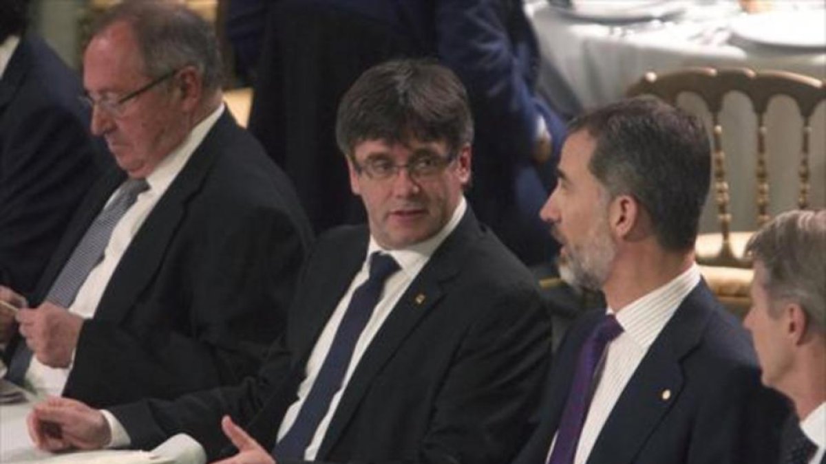 Puigdemont y Felipe VI dialogan durante la cena de bienvenida al MWC que se ofreció anoche en el Palau de la Música.-MARTA PÉREZ