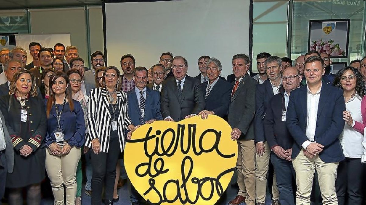 El presidente de la Junta posa tras un logotipo de Tierra de Sabor, acompañado por la consejera de Agricultura y productores de Castilla y León presentes en la feria.-J.M. LOSTAU