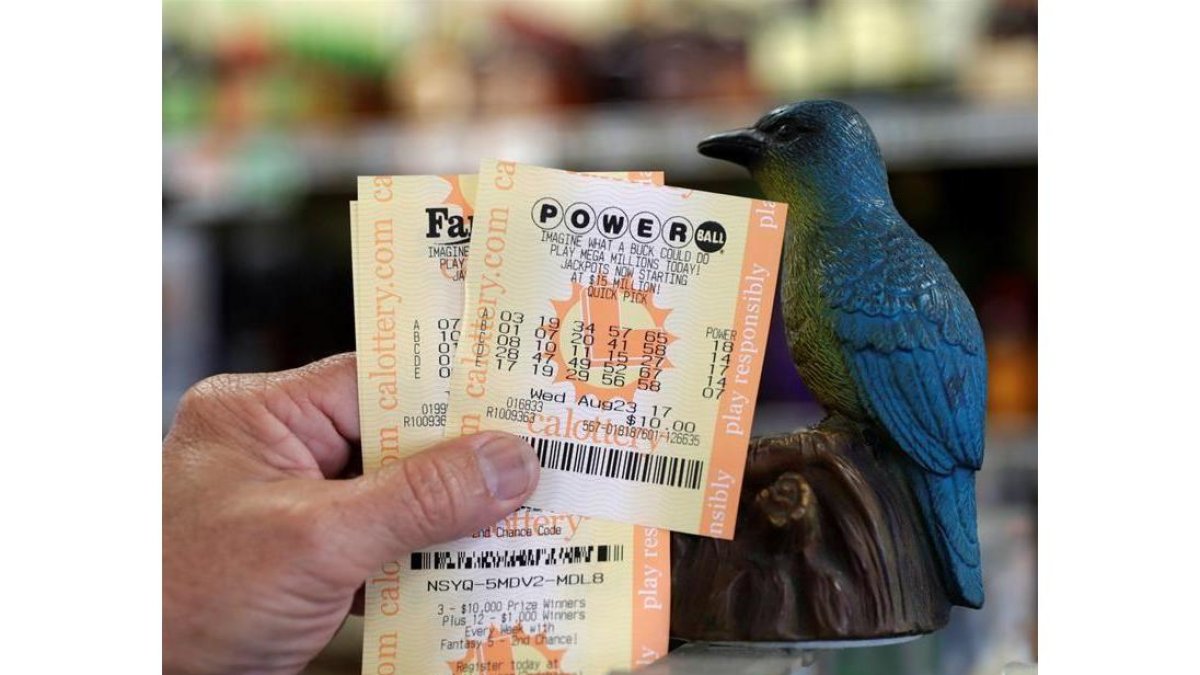 Un hombre muestra sus billetes de lotería Powerball en la tienda de licor Bluebird el 22 de agosto de 2017, en Hawthorne, California (EE.UU.).-EFE