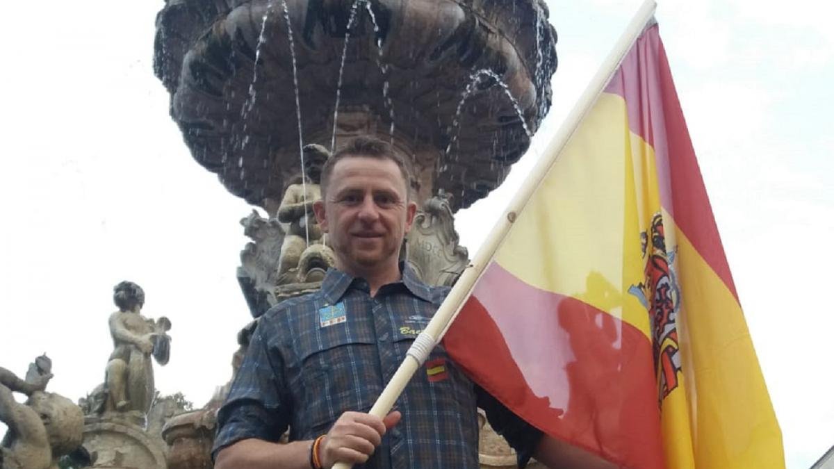 El pescador leonés David García posa con la bandera de España.-L. DE LA FUENTE