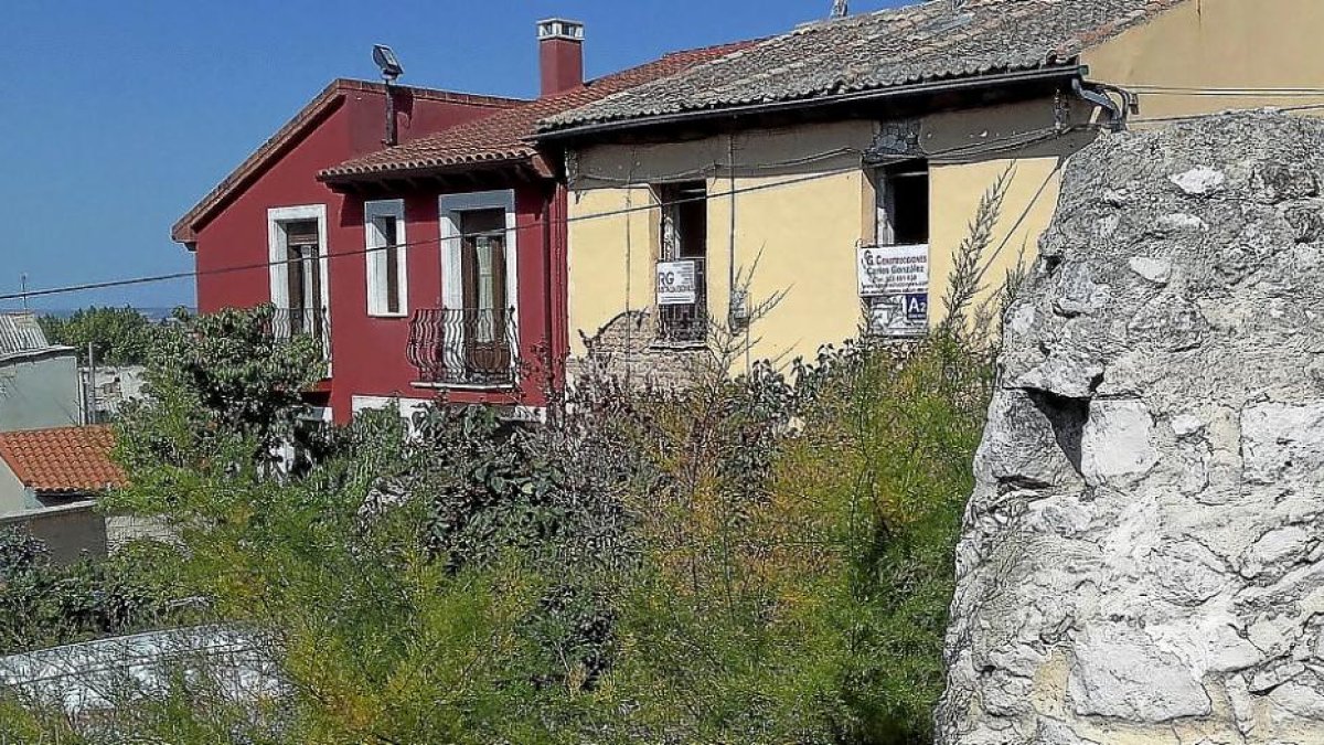 Edificio en rehabilitación, con el cartel de la constructora en las ventanas, en la calle Subida al Hospital de Peñafiel.-S. G. C.