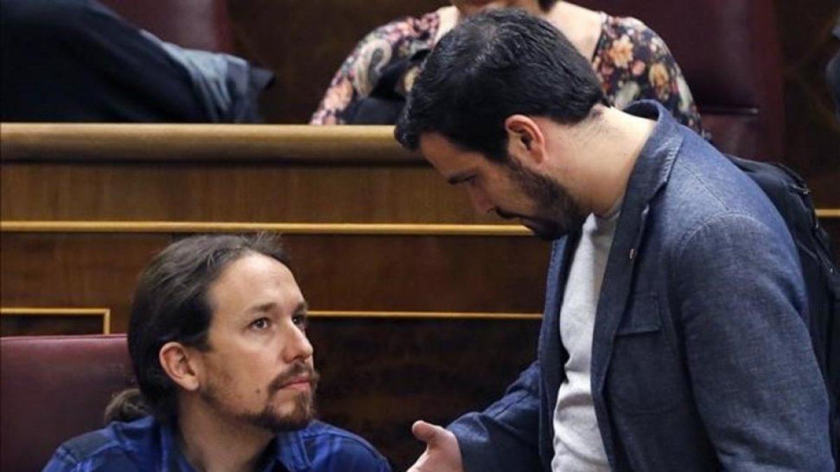 Pablo Iglesias y Alberto Garzón conversan en el hemiciclo del Congreso.-KIKO HUESCA / EFE
