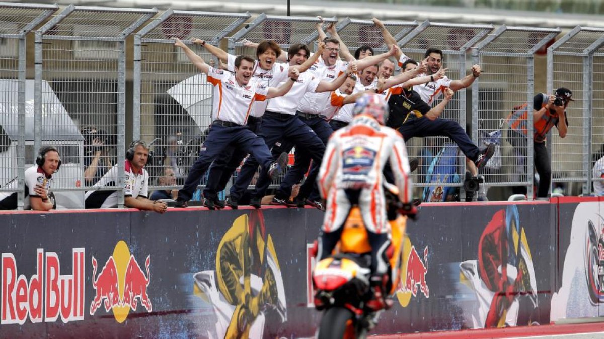 Los mecánicos de Marc Márquez reciben a su campeón encaramados al muro de Austin tras su última victoria.-