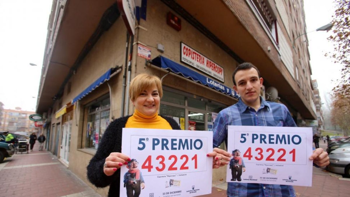 La propietaria de la Copiateria Hipercopy muestra el número agraciado con un quinto premio junto a su hijo frente al establecimiento-Ical