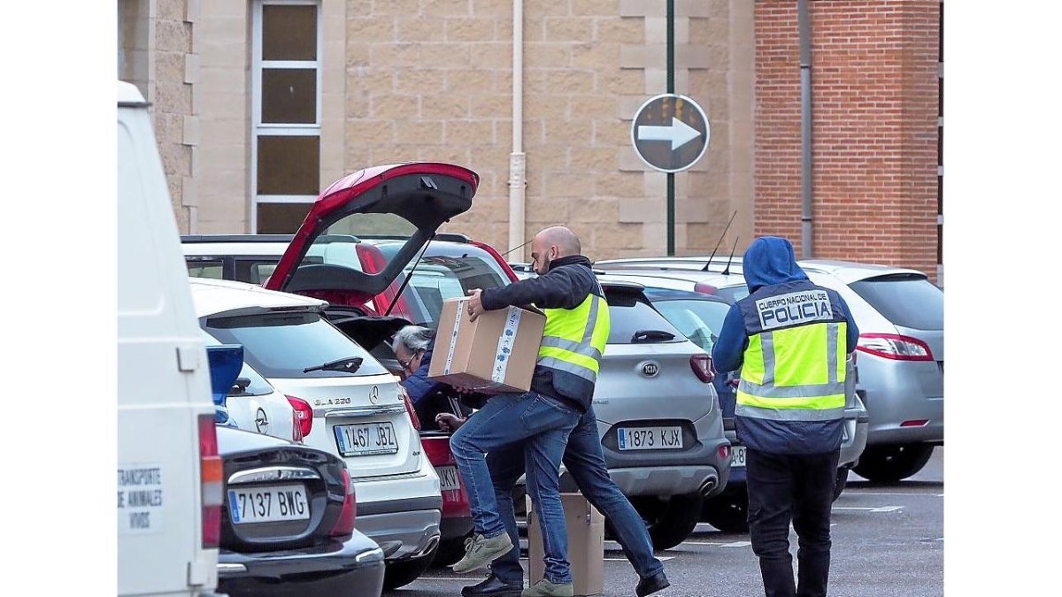 Agentes introducen en un coche las cajas con la documentación incautada en el tanatorio del Camino del Cementerio.-MIGUEL ÁNGEL SANTOS / PHOTOGENIC