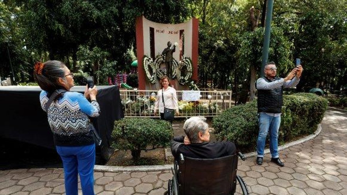 Seguidores del fallecido cantante José José visitan una estatua del artista adornada con flores.-EFE
