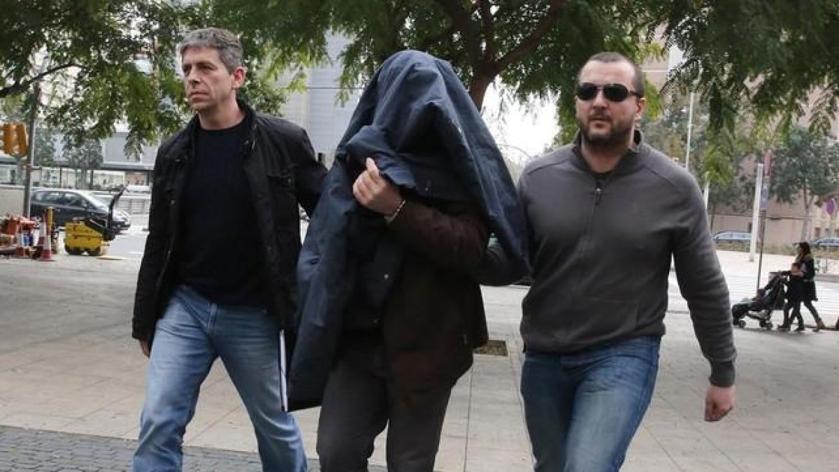 Joaquim Benítez entra en la Ciutat de la Justícia de BCN custodiado por dos mossos.-