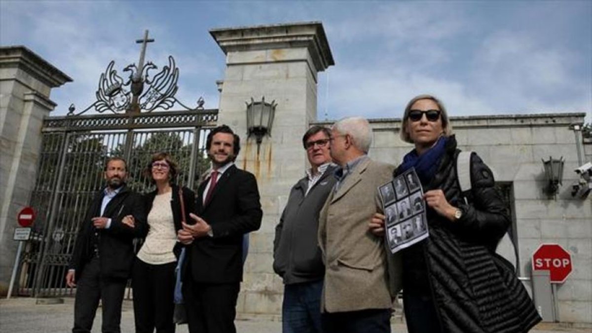 Familiares de víctimas de la guerra civil, frente a la entrada a la Basílica del Valle de los Caídos el pasado 23 de abril. En el centro, su abogado, Eduardo Ranz-JUAN MEDINA (REUTERS)