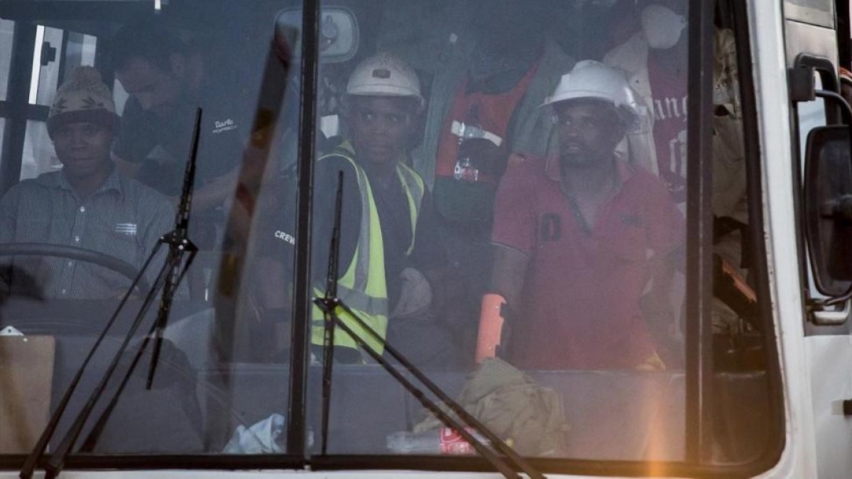 Algunos de los cientos de mineros rescatados, en un autobús, cerca de la mina Beatrix, cerca de Welkom, el 2 de febrero.-/ AP