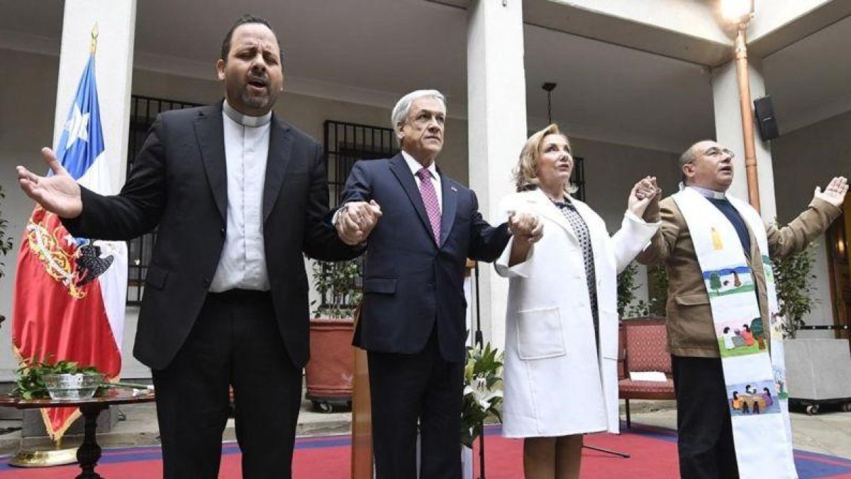 El presidente de Chile, Sebastián Piñera, (segundo por la izquierda) y su esposa, Cecilia Morel, rezan junto a dos religiosos en el acto conmemorativo del aniversario del golpe de Estado de 1973.-EFE