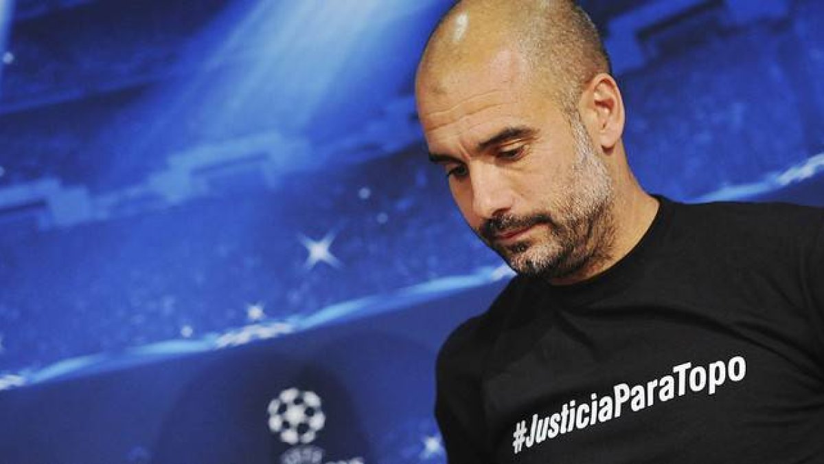 Pep Guardiola, con una camiseta con el lema #JusticiaparaTopo, durante la rueda de prensa previa la partido contra el Oporto en Múnich.-Foto: EFE / ANDREAS GEBERT