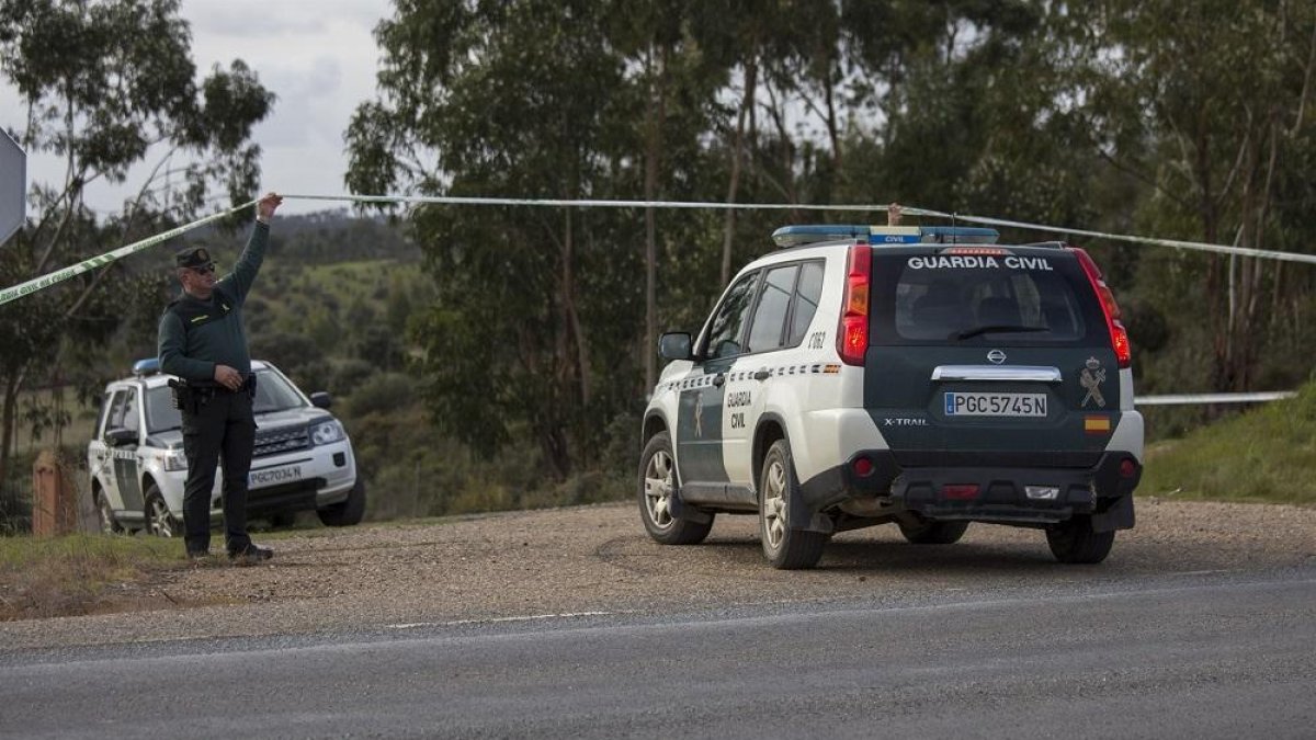 Un Guardia Civil levanta la cinta del cordón policial durante la investigación.-EUROPA PRESS