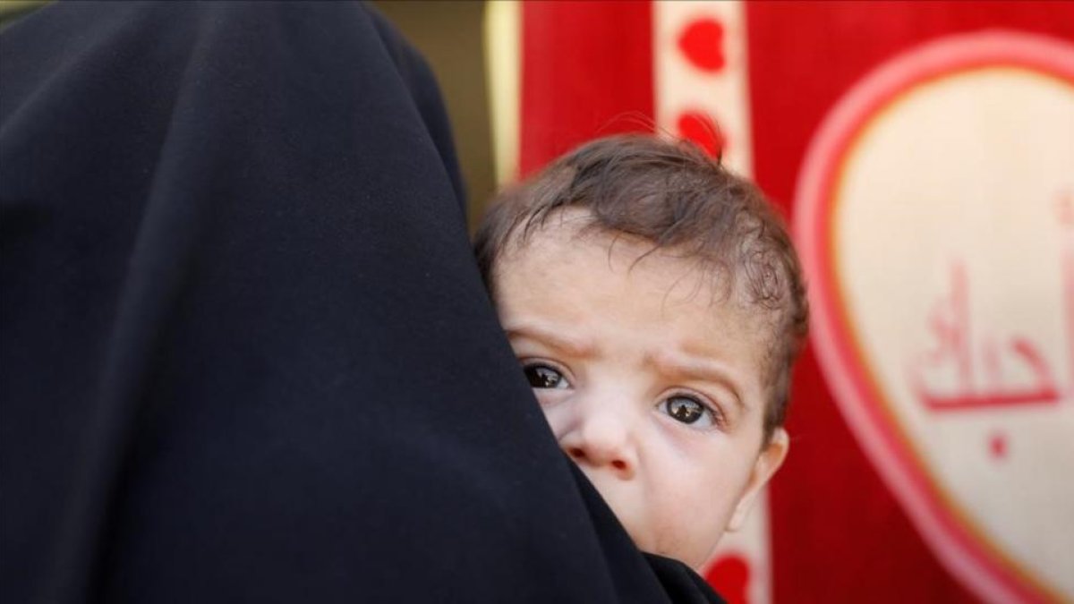 Una mujer con su hijo en brazos en una hospital móvil en el oeste de la ciudad de Mosul.-REUTERS
