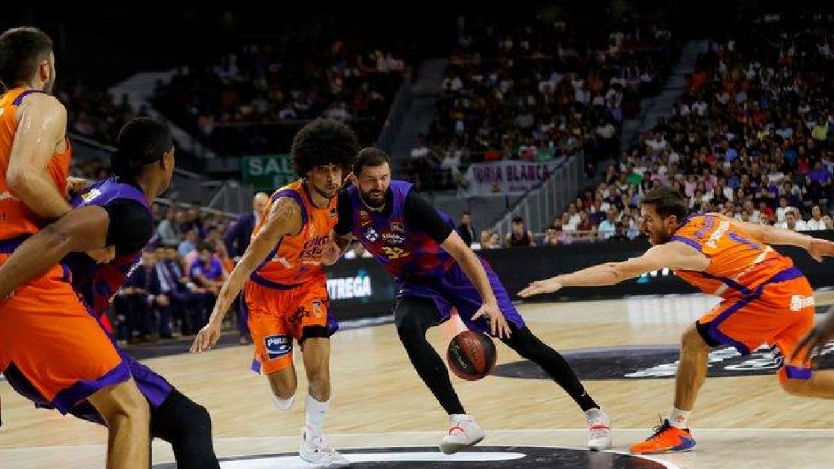 El barcelonista Mirotic (c) intenta culminar una jugada ante Valencia Basket.-EFE