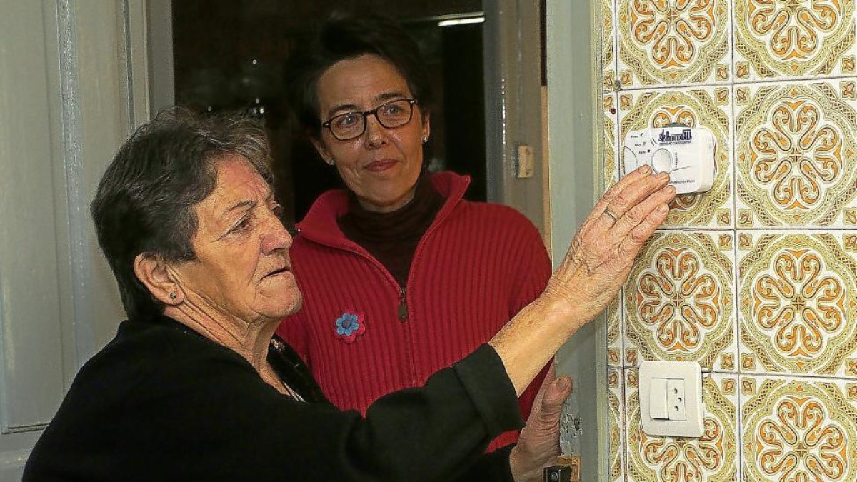 Una usuaria del servicio de ayuda a domicilio manipula un detector de monóxido instalado en su domicilio.