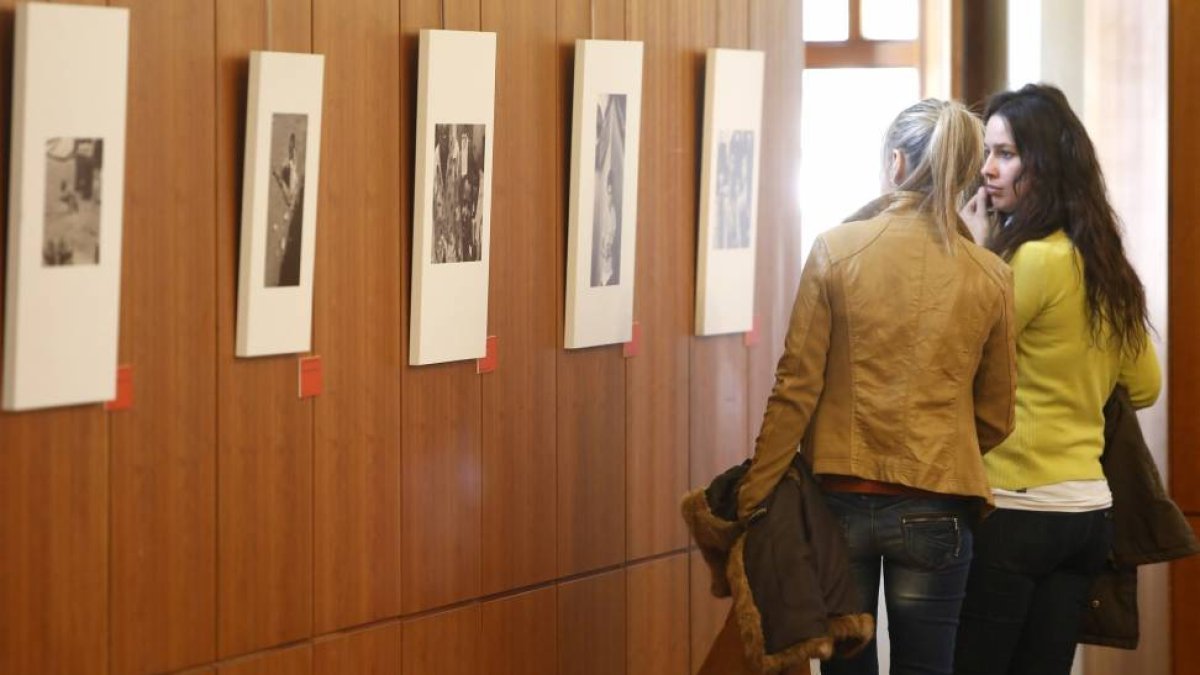 Dos personas observan las imágenes de la exposición `150 años de Acción Humanitaria con las Víctimas de la Guerra'-Ical