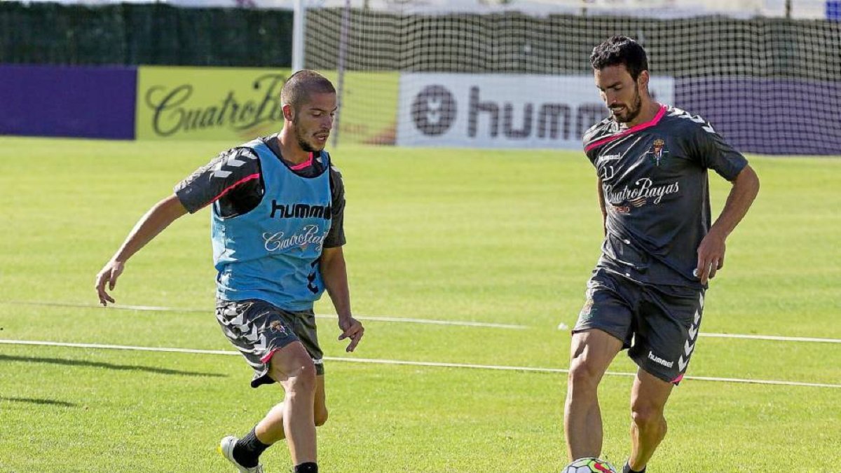 Alfaro se lleva el balón ante la presencia de Caye Quintana en el entrenamiento de ayer.-Pablo Requejo