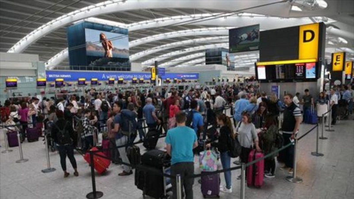 Colas de pasajeros originadas por el fallo informático, en la terminal 5 del aeropuerto inglés de Heathrow, ayer.-AFP / DANIEL LEAL-OLIVAS