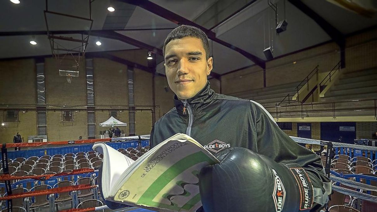 Miguel Cuadrado posa en el ring de Rondilla antes de su último combate con uno de los libros de Ingerniería mecánica.-MIGUEL ÁNGEL SANTOS