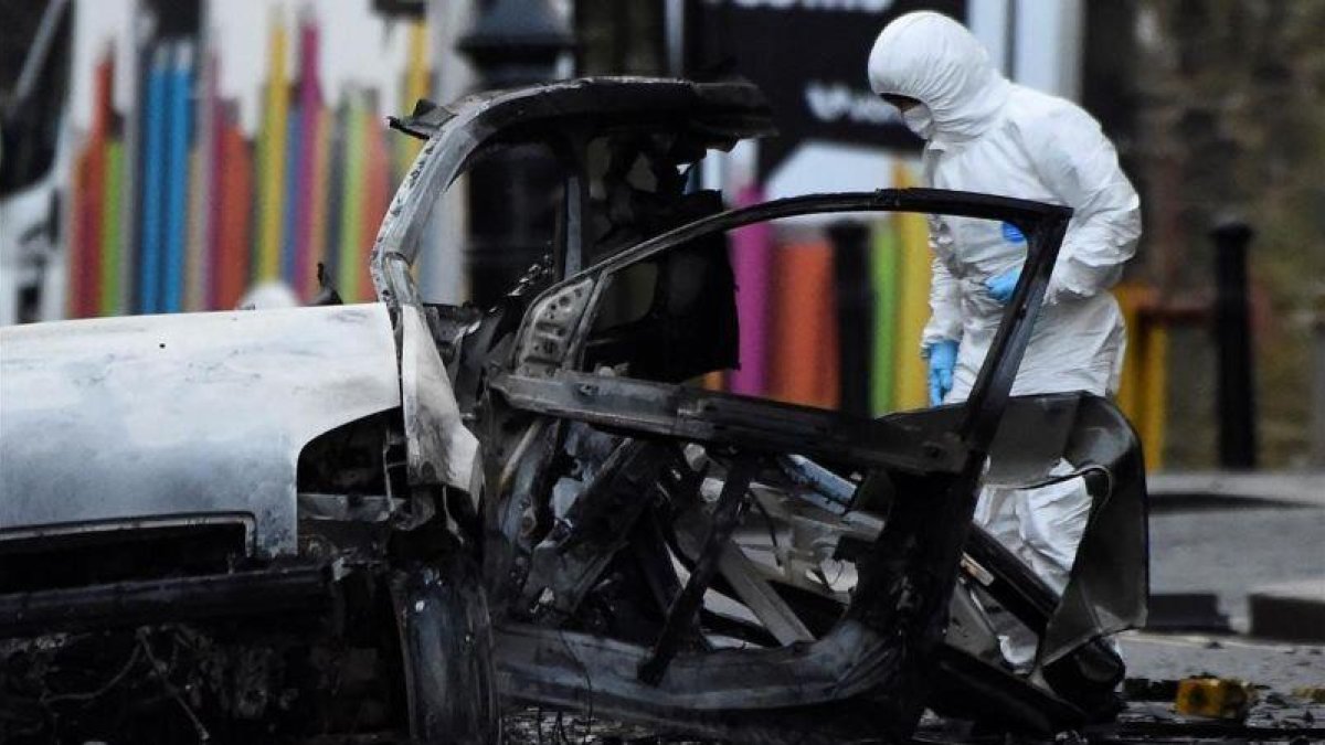 Un forense inspecciona la zona donde ha explotado el coche bomba en Londonderry.-CLODAGH KILCOYNE (REUTERS)