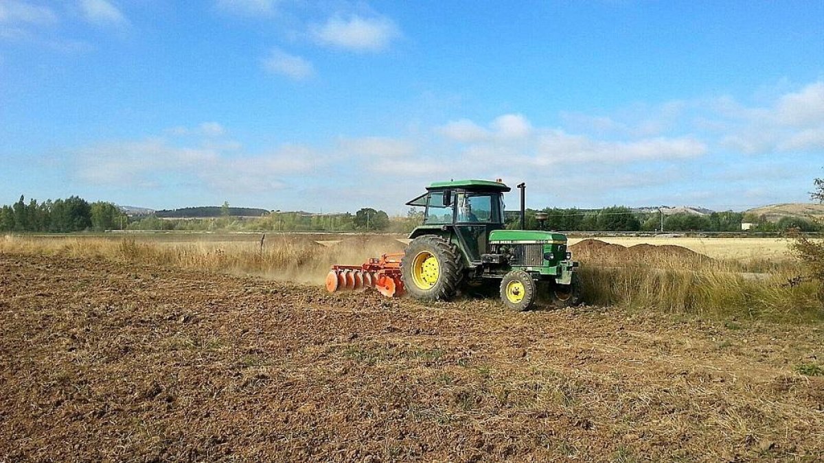 Un tractor haciendo las labores en la explotación ecológica ubicada en el municipio palentino de Villallano.-E.M.