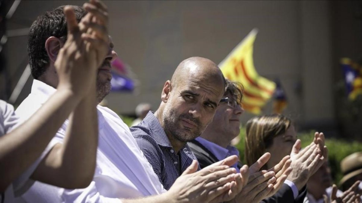 Pep Guardiola, entre Carles Puigdemont y Oriol Junqueras, este domingo, en la manifestación de la ANC, Òmnium y la AMI.-JOAN CORTADELLAS