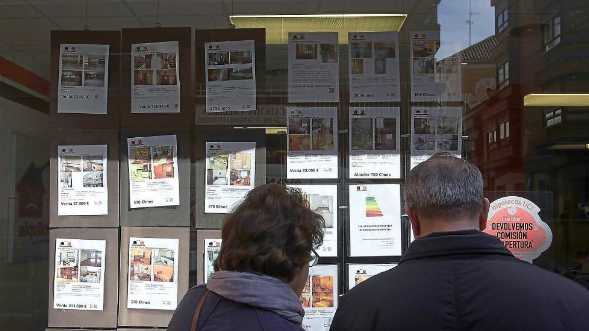 Una pareja mira anuncios de una inmobiliaria.-ICAL