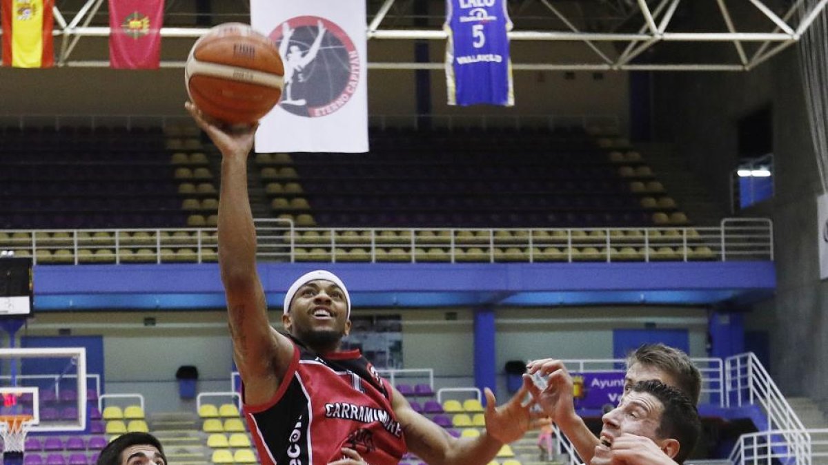 Wade-Chatman lanza a canasta ante la presencia de Sergio de la Fuente y los jugadores rivales.-J.M.LOSTAU