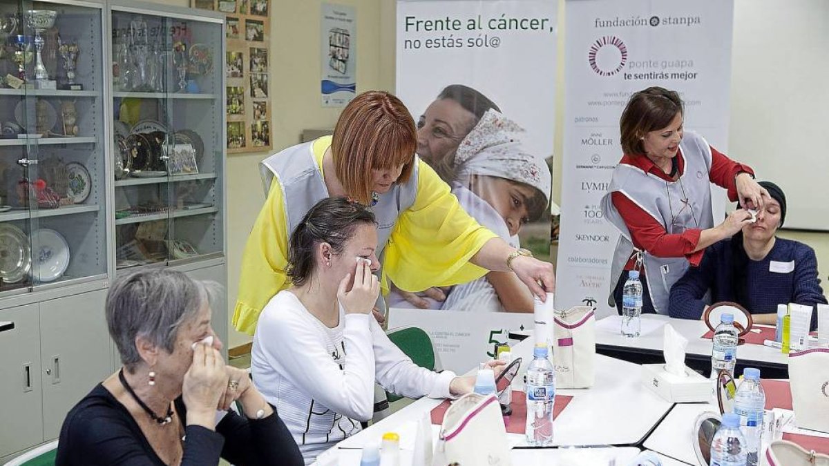 Tres participantes del taller de maquillaje escuchan las explicaciones de Peña y María José-José C. Castillo