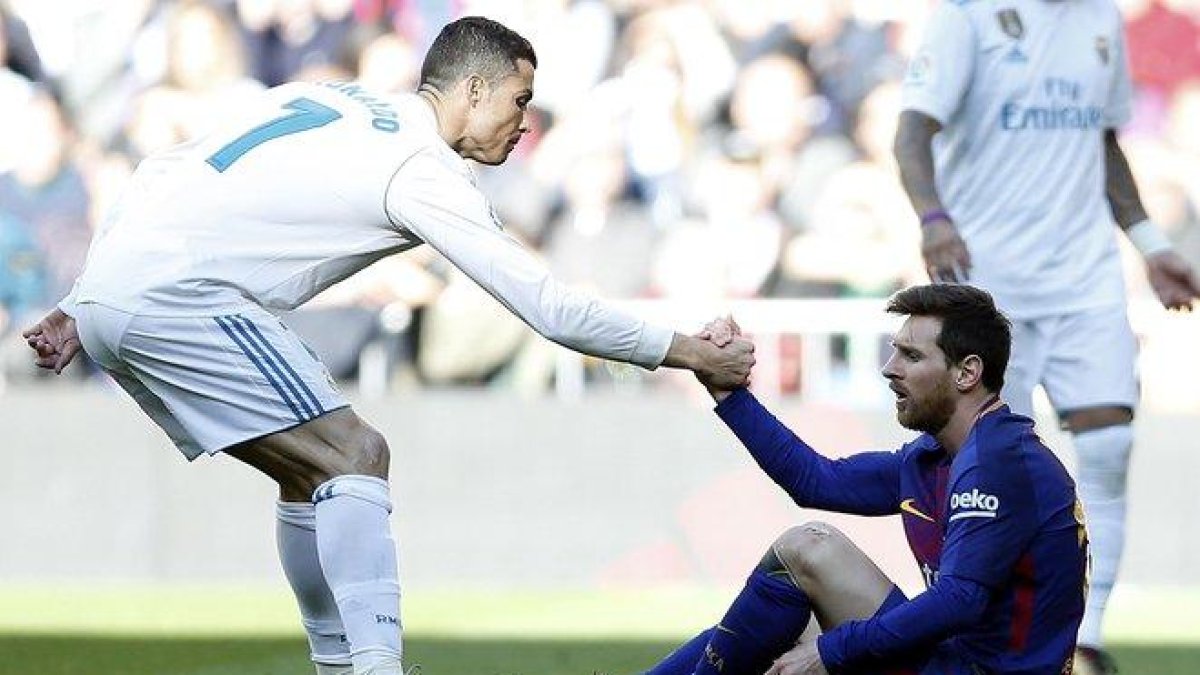 Cristiano ayuda a Messi a levantarse tras una falta que le cometieron en un clásico jugado en Madrid el 2017.-AP