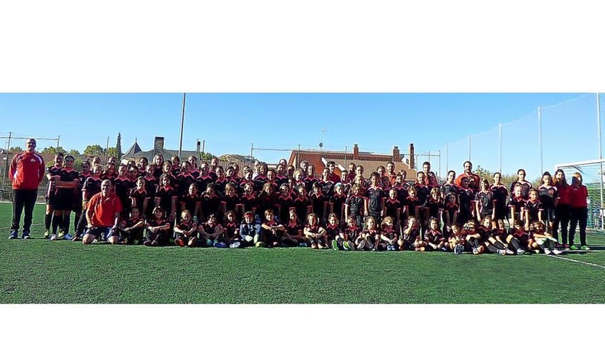 La gran familia de la Escuela de fútbol femenino de la FCyLF, compuesta por jugadoras y cuerpo técnico, posa en las instalaciones de Arroyo.-EL MUNDO