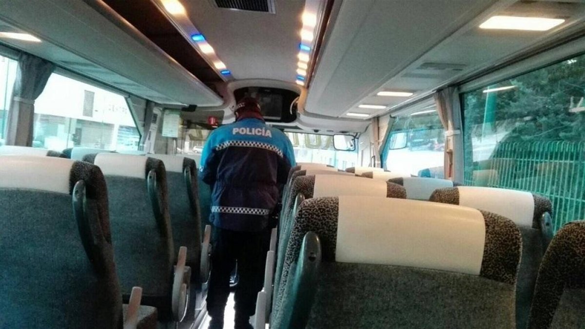 Un policía municipal de Valladolid realizando una inspección a un autobús escolar.-EUROPA PRESS