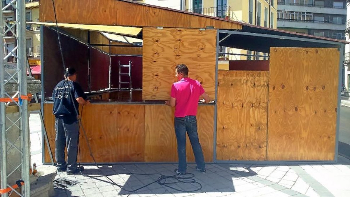 Dos hosteleros montan una caseta de la Feria de Día junto a La Antigua.-E. M.