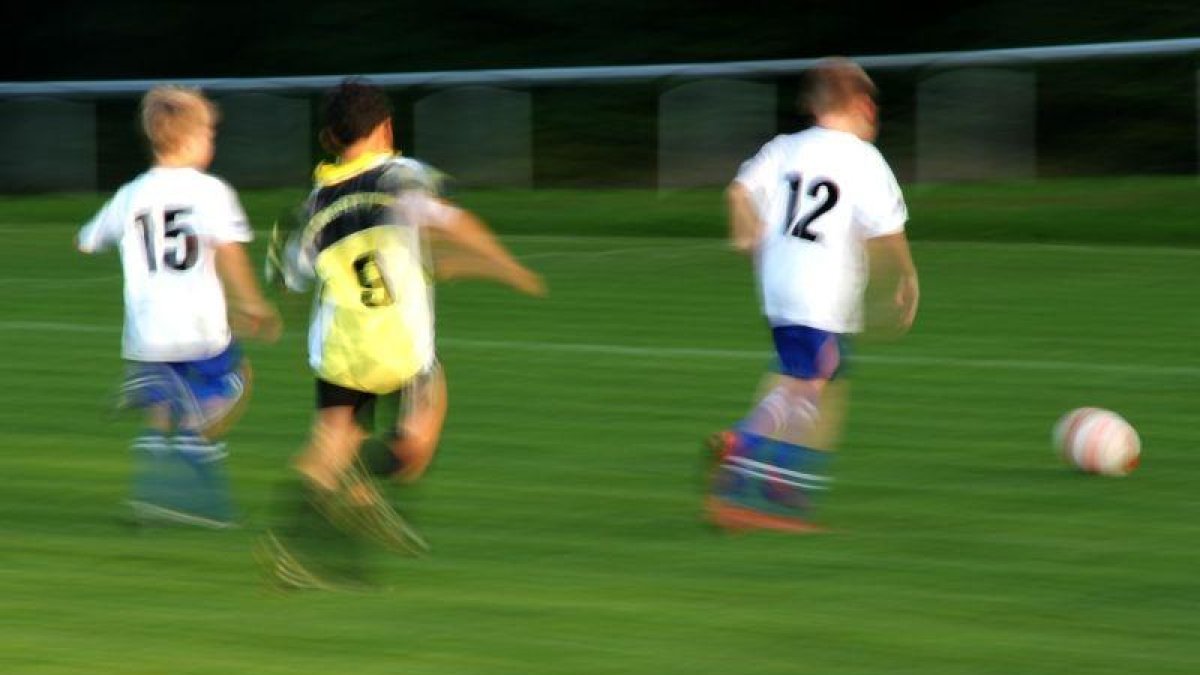 Unos niños juegan un partido de fútbol.-