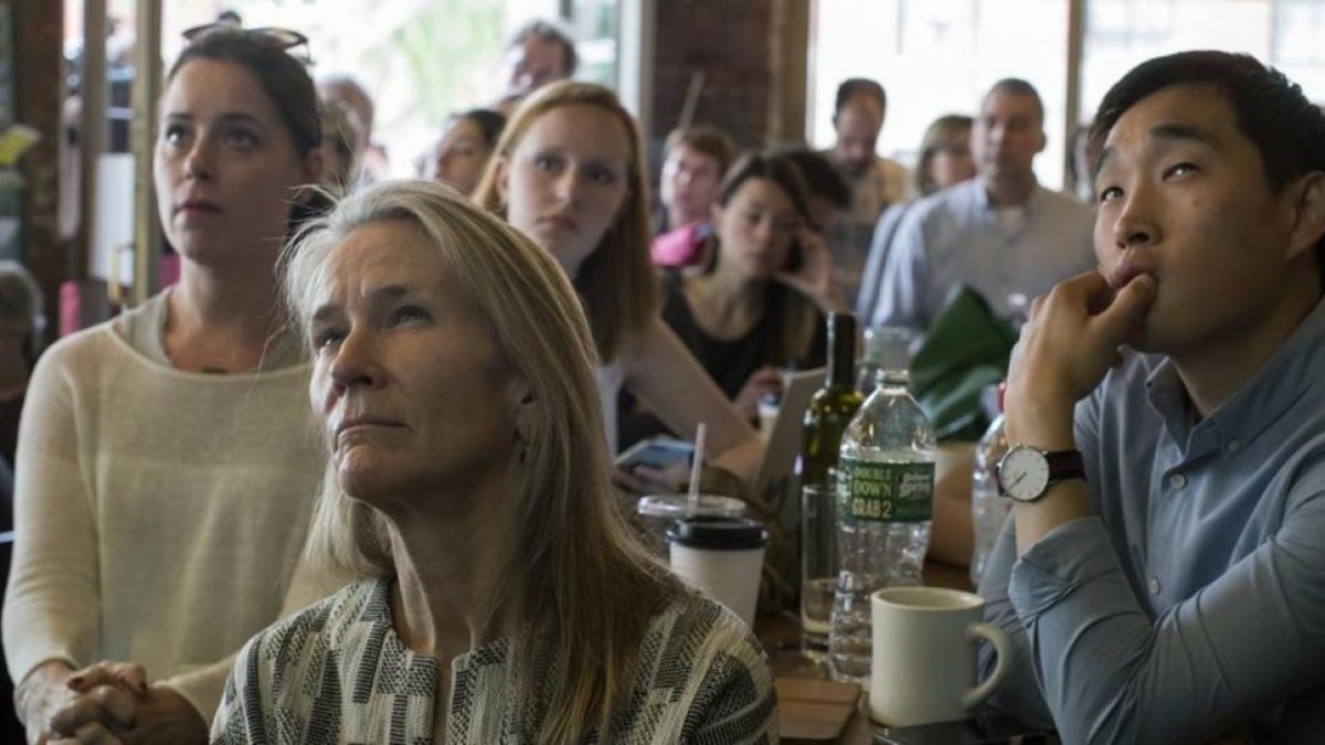 Varios clientes observan por televisión la comparecencia de Comey ante el comité de inteligencia del Senado, en el Building on Bond, en Brooklyn (Nueva York), el 8 de junio.-AP / MARY ALTAFFER