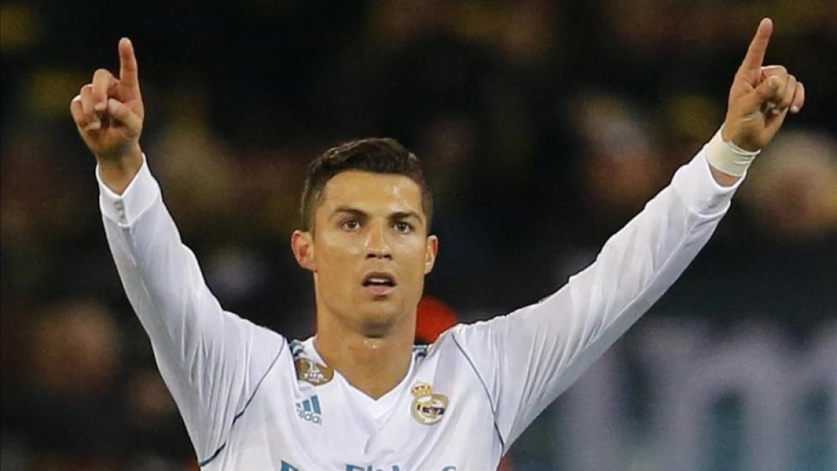 Cristiano levanta sus brazos al cielo tras el triunfo del Madrid ante el Dortmund.-AP / MICHAEL PROBST
