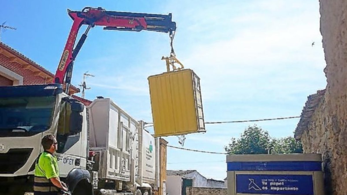Un camión de la basura recoge los residuos del contenedor amarillo.