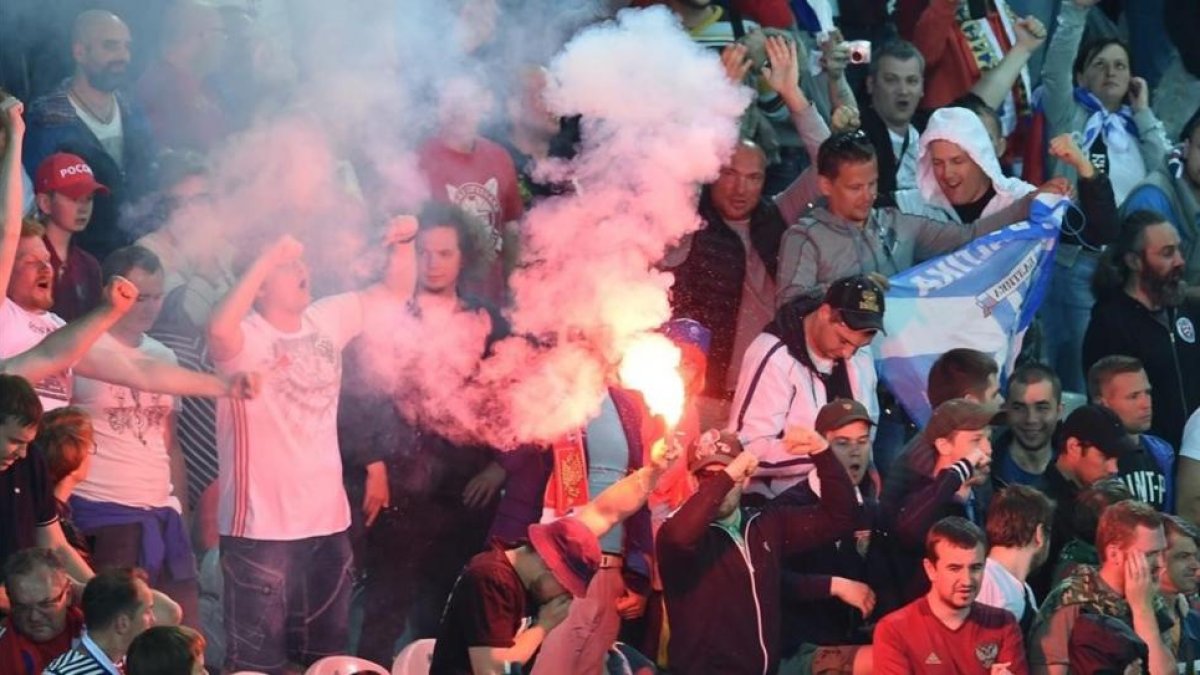 Hinchas rusos encienden bengalas durante el partido ante Eslovaquia en Lille.-EFE / ANDY RAIN