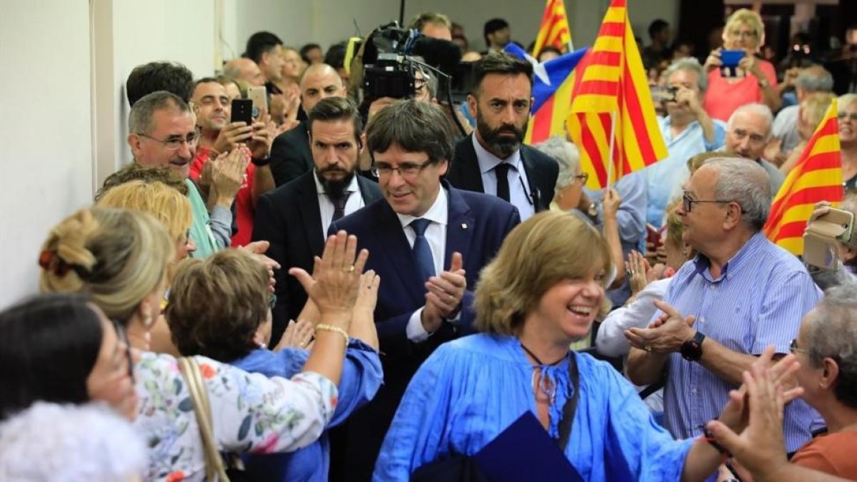 El president Puigdemont, tras la consellera Meritxell Borràs, a su llegada la míting en el Casino de l'Hospitalet-FERRAN NADEU