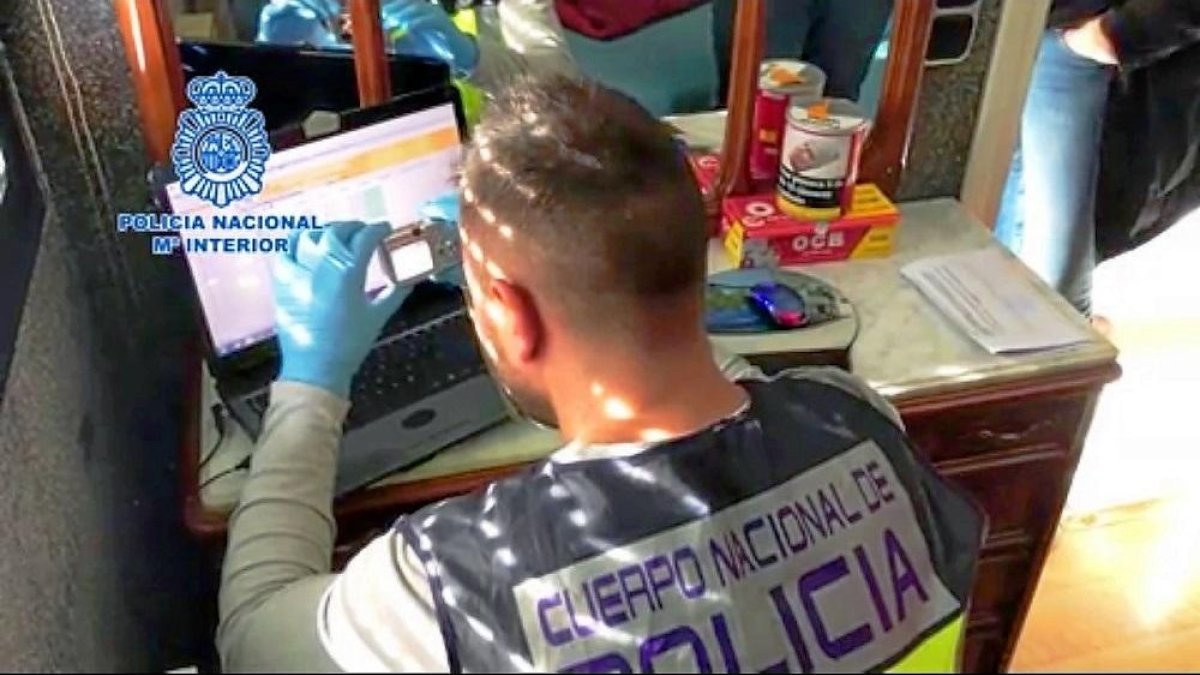 Un agente de la Policía Nacional toma fotografías en el ordenador del detenido, A. J.C.M., de 50 años, residente en un piso céntrico de Valladolid.-E. M.