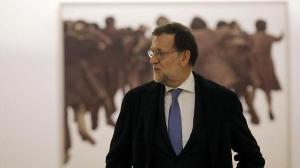 Mariano Rajoy, presidente del Gobierno en funciones junto al cuadro de Juan Genovés, presentado el jueves, después de recoger las credenciales de diputado hoy, en el Congreso de los Diputados.-JOSÉ LUIS ROCA
