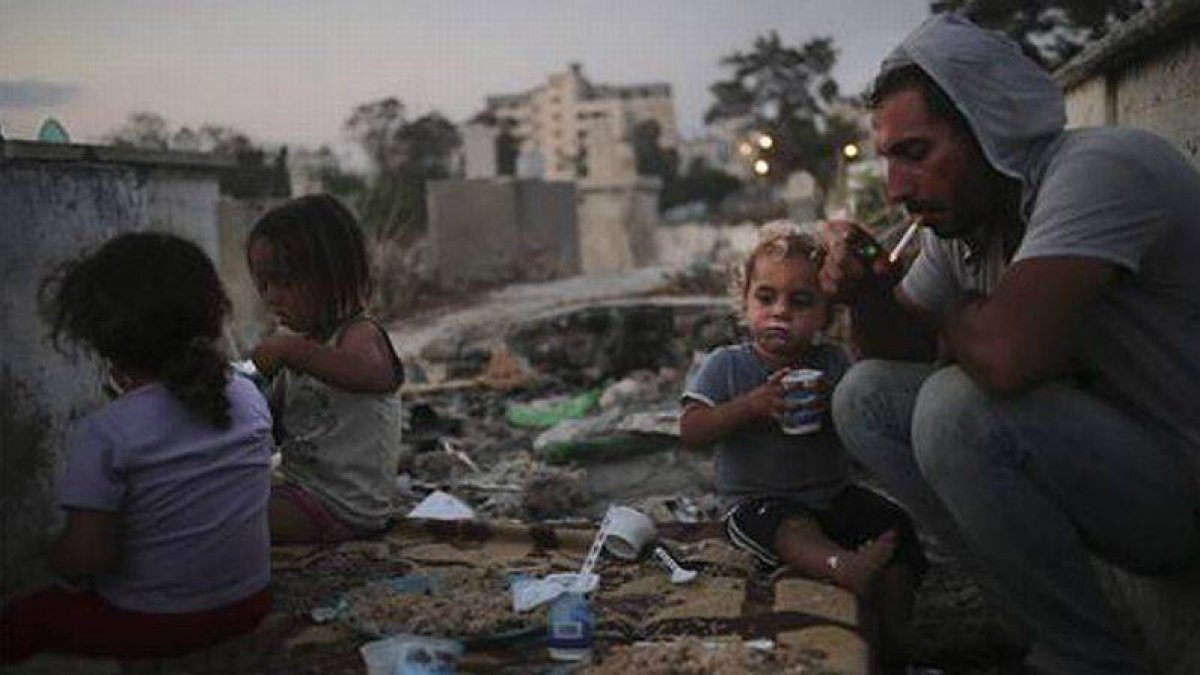 Una familia en el cementerio de Almaamadani, en Gaza.-Foto: ALI ALI / EFE