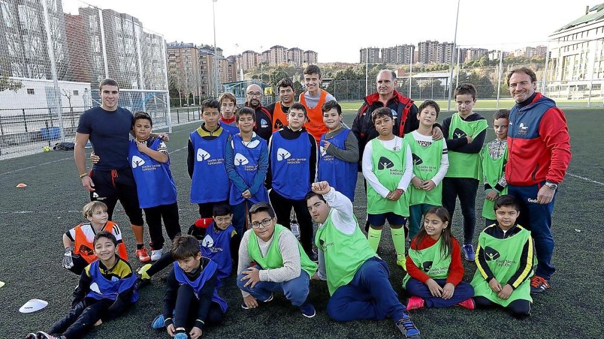 Los componentes de la escuela de la Fundación Eusebio Sacristán posan en las instalaciones de El Palero junto a los monitores, entre ellos el exfutbolista Juan Carlos.-J.M. LOSTAU