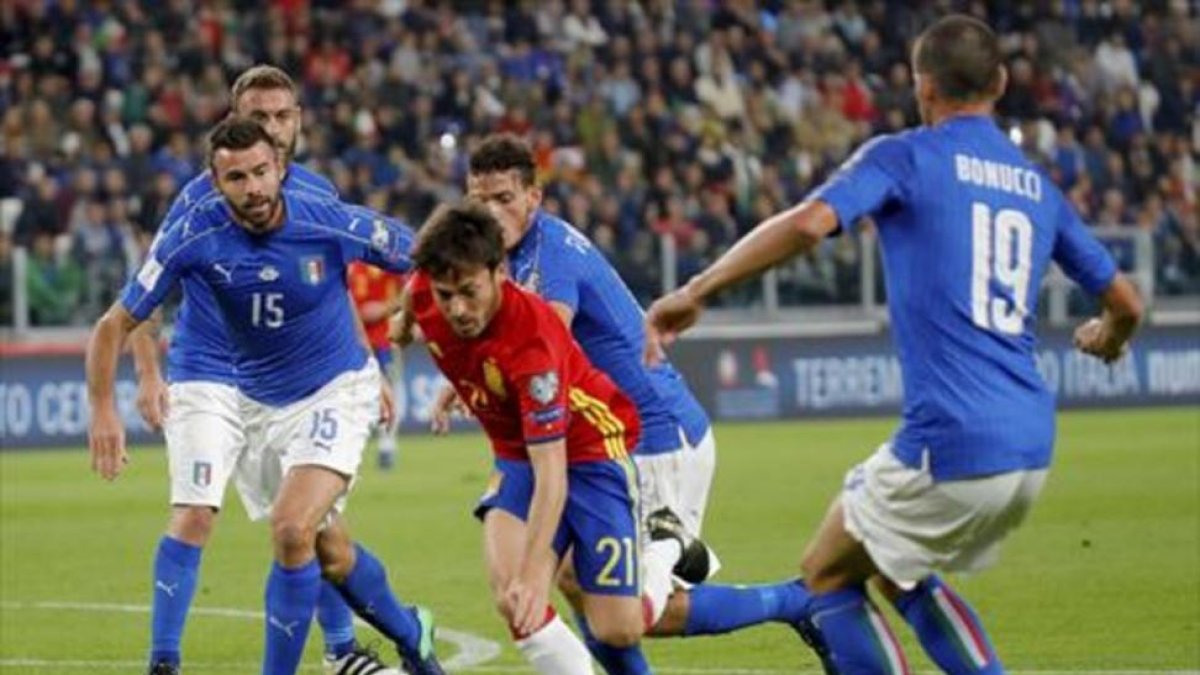 Silva, uno de los mejores, se mete entre tres defensas italianos.-EFE / JUANJO MARTÍN